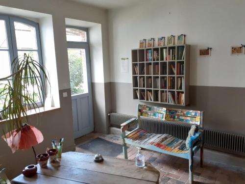 a living room with a book shelf with books at Ferme de la Basse-cour in Gommerville