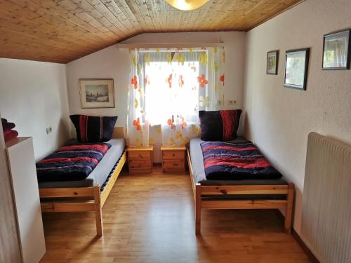 two beds in a small room with a window at Dornbirn Hills, Watzenegg 45 in Dornbirn