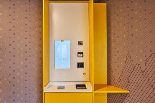 a yellow and white machine in a room at McDreams Hotel München-Nord in Eching
