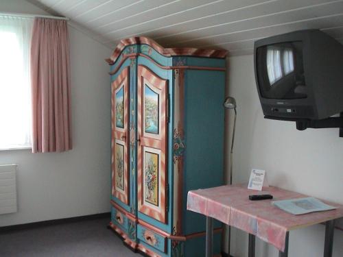 um grande armário de madeira com uma televisão num quarto em Panorama Hotel Freudenberg em Appenzell