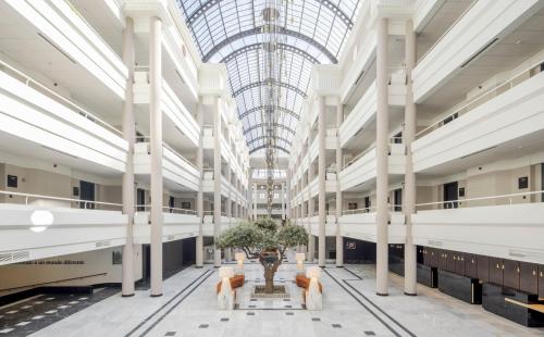 a large building with white columns and a glass ceiling at Ilunion Alcora Sevilla in San Juan de Aznalfarache