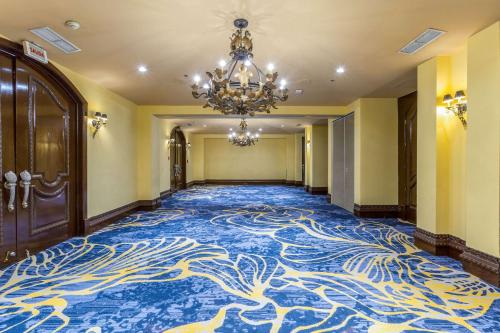 a hallway with a blue and white carpet with a chandelier at Clarion Hotel Real Tegucigalpa in Tegucigalpa