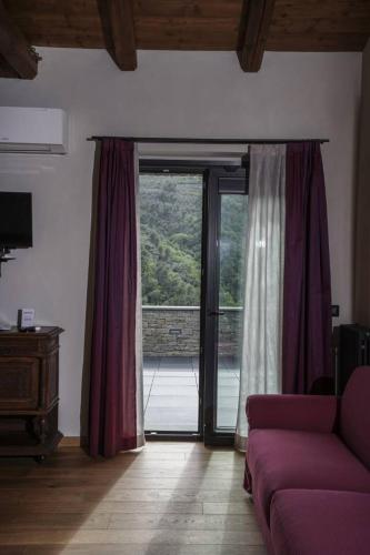 a living room with a couch and a sliding glass door at B&B il Pianolo in Perinaldo