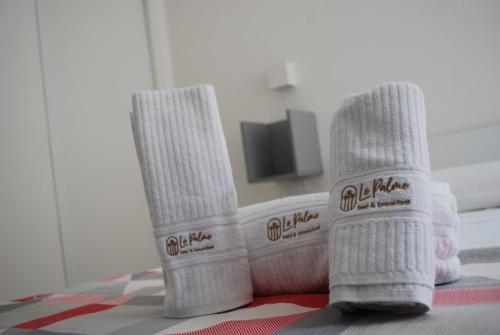 two white socks sitting on a table with a television at B&B Le Palme in Diamante