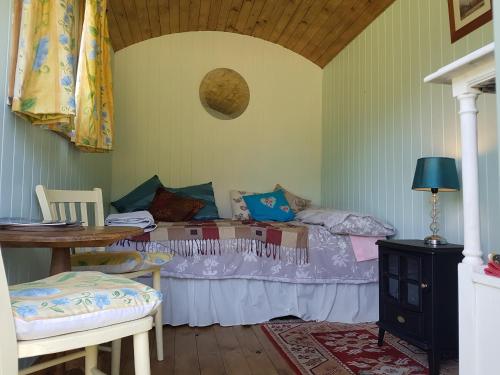 a bedroom with a bed and a table and chairs at Shepherds hut Dolly wagon in Keswick