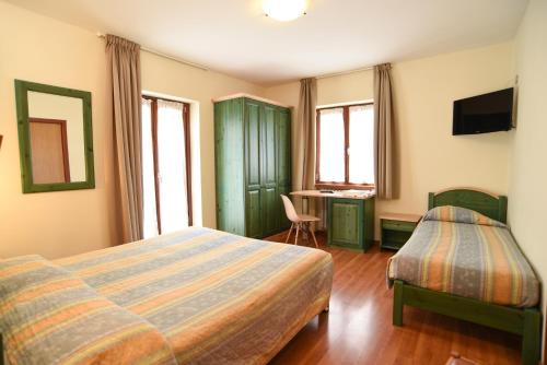 ピエヴェペーラゴにあるAlbergo Bucaneveのベッド2台と机があるホテルの部屋