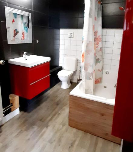 a bathroom with a toilet and a sink and a tub at Le Bonheur Cristallin in Rochefort