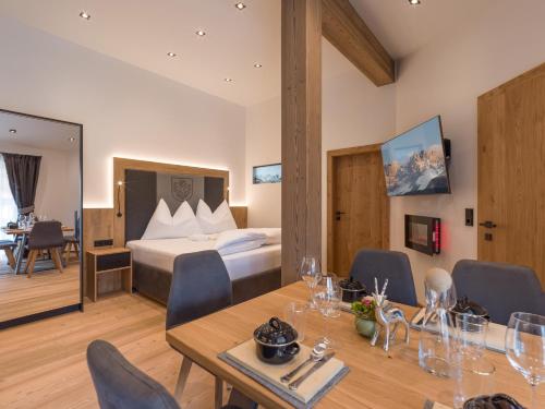 pokój hotelowy z łóżkiem, stołem i krzesłami w obiekcie Dorfkaiser Appartements w mieście Going