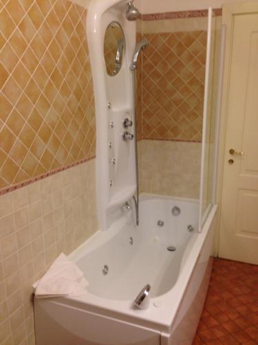 a bathroom with a bath tub with a shower at Hotel Barolo in Barolo