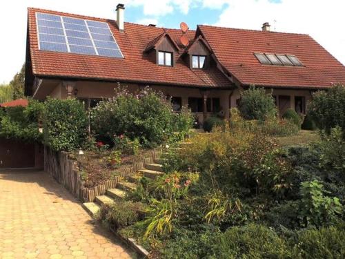 ein Haus mit einem Dach und einem Garten davor in der Unterkunft Chambres d'hotes Coeur de Sundgau in Leymen