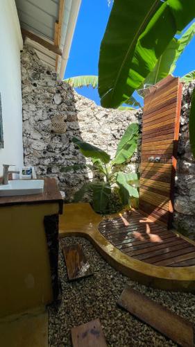 a wooden bench sitting next to a stone wall at Atii Garden Bungalows in Nungwi