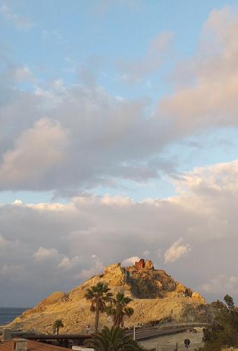 ヴルカーノにあるHotel Torreの椰子の木と曇り空のある山