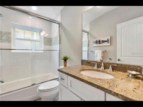 a bathroom with a sink and a toilet and a shower at AMI/Holmes Beach - 3/2 Home - Private Heated Pool and Yard - walk to beach in Holmes Beach