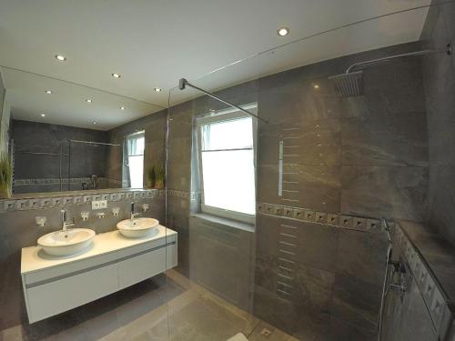 a bathroom with two sinks and a window at Ruegen-Beach-House-Haus-Palstek in Göhren