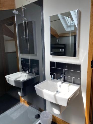 a bathroom with two sinks and a mirror at Creber Cottage in Totnes