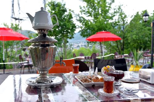 a table with a tea kettle and a plate of food at Ansera 55 Hotel Sheki in Sheki