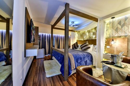 a bedroom with a bed with a blue comforter at Caminho das Pedras Pousada de Charme in Campos do Jordão
