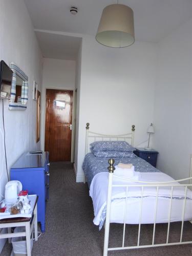 a bedroom with a bed and a tv and a table at Shipping Lanes Hotel in Morecambe