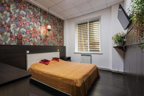 a bedroom with a bed and a window at Hostel Zaezzhiy Dvor in Abakan