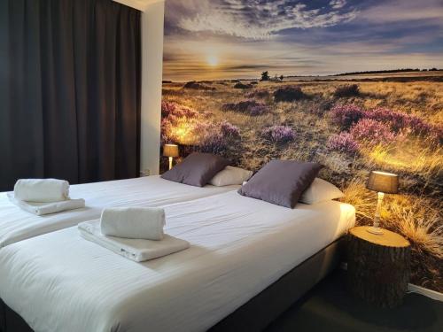 a bedroom with a bed with a painting of a field at Hotel de Foreesten in Vierhouten