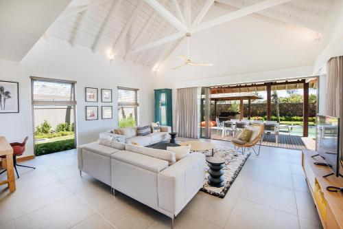 a living room with a couch and a table at Mythic Suites & Villas by MJ Holidays in Grand Gaube