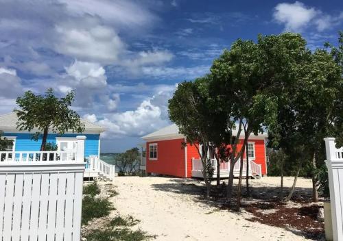a house on the beach with a white fence at Mangrove Cay Sea View Villas in Behring Point
