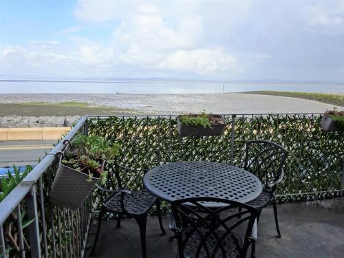 einen Tisch und Stühle auf einem Balkon mit Meerblick in der Unterkunft Shipping Lanes Hotel in Morecambe