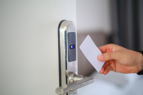 a person holding a piece of paper in a door at Regina Garden Vlore in Vlorë
