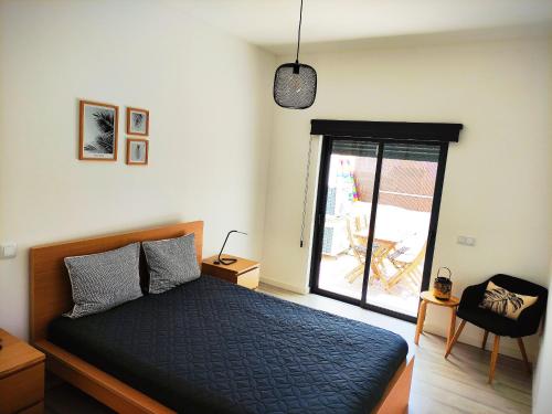 a bedroom with a bed and a door to a patio at Apartamento Rooftop Montenegro in Faro