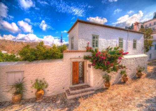 a building with potted plants on the side of it at Cotommatae Hydra 1810 in Hydra