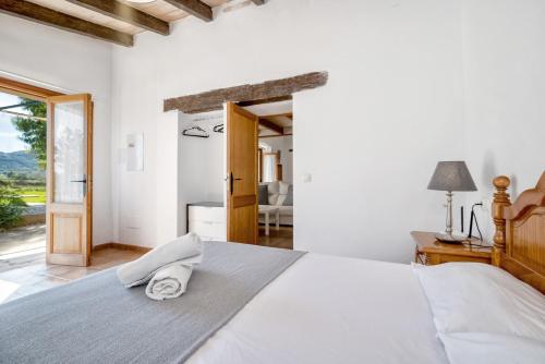 a white bedroom with a bed and a refrigerator at Es Camp Pla in Sineu