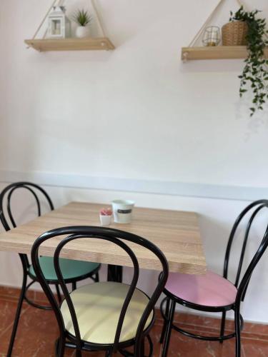 a wooden table with two chairs and a wooden table with shelves at Hostal Xaraiba in Sanxenxo