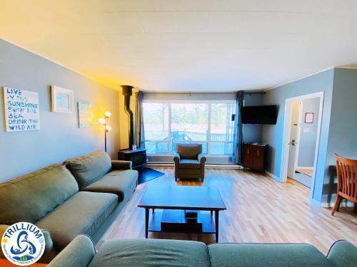 a living room with a couch and a table at The Beach 2 Cottage - Wifi, Netflix, Steps to the Beach in Wasaga Beach