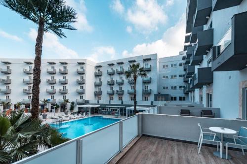 einen Balkon mit Blick auf ein Hotel mit Pool in der Unterkunft Bora Bora Ibiza Malta Resort - Music Hotel - Adults Only 18 plus in St Paul's Bay