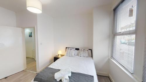 ロンドンにあるThe Rock Apartments IIの白いベッドルーム(ベッド1台、窓付)