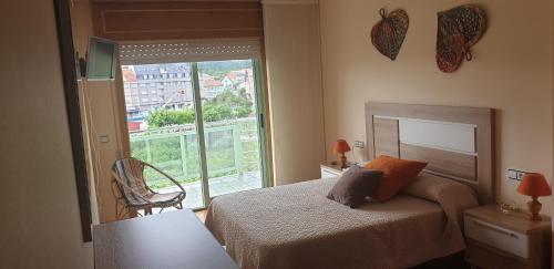 a bedroom with a bed and a large window at Piso Portonovo Sanxenxo in Portonovo