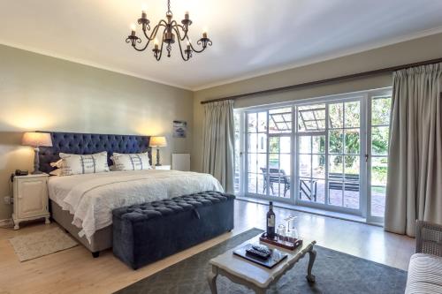a bedroom with a large bed and a couch at Whale Rock Luxury Lodge in Hermanus
