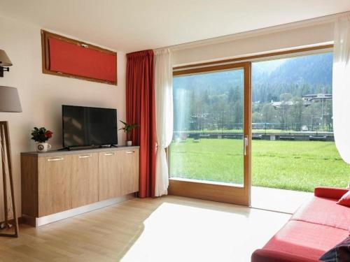 a living room with a television and a large window at Gressoney Saint-Jean Halldis Apartments in Gressoney-Saint-Jean