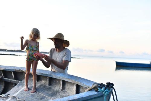 a man and a little girl standing on a boat at Mythic Suites & Villas by MJ Holidays in Grand Gaube