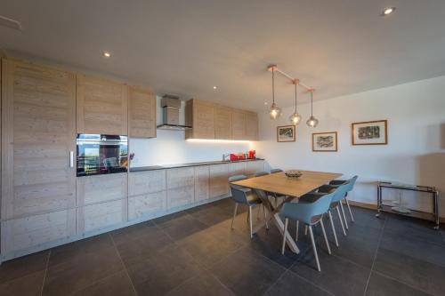 a kitchen with a wooden table and chairs at Apartment La Forêt 5 - Spa access - Centre Station in Nendaz