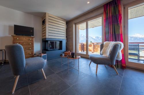 a living room with two chairs and a fireplace at Apartment La Forêt 5 - Spa access - Centre Station in Nendaz