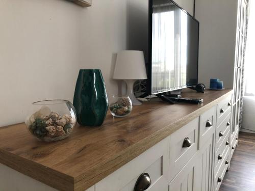 eine hölzerne Kommode mit einem TV darüber in der Unterkunft Sunny Shore Burgas Apartment in Burgas City