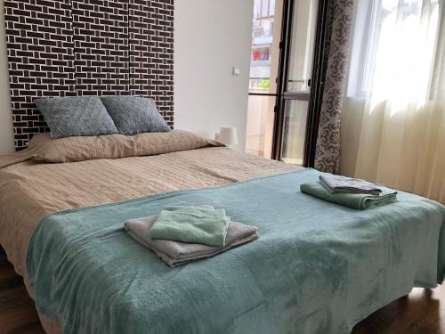 ein Schlafzimmer mit einem Bett mit zwei Handtüchern darauf in der Unterkunft Sunny Shore Burgas Apartment in Burgas City