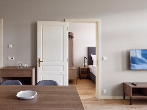 a living room with a table and a bedroom at Franz BY ZEITRAUM in Prague