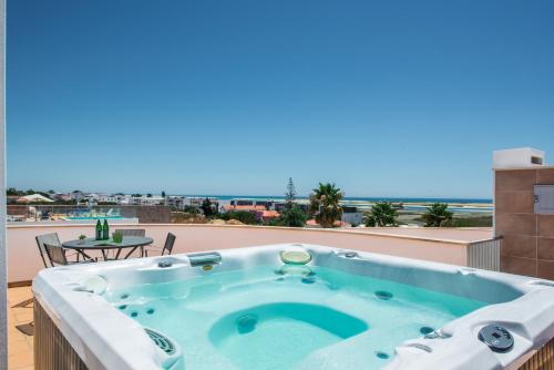a hot tub on a balcony with a view of the ocean at Fuseta Ria Resort - Villa Jasmine - Pool, Jacuzzi & Sea Views in Fuzeta