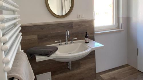 a white sink in a bathroom with a mirror at Café Ilse - Ferienwohnungen in Ranis
