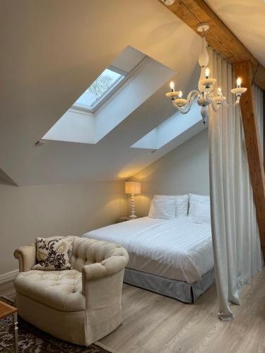 a bedroom with a bed and a couch and a skylight at Schloss Fall, Keila-Joa in Keila-Joa