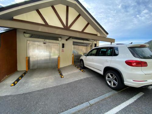 a white suv parked in front of a garage at P&C Ribasol in Arinsal