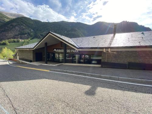 a building on a street with mountains in the background at P&C Ribasol in Arinsal