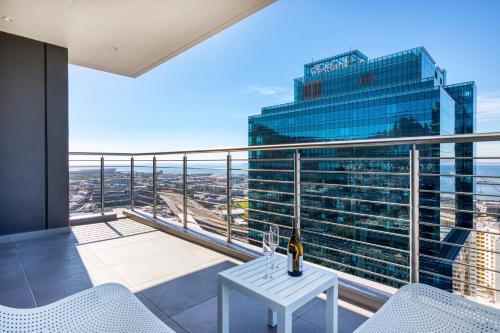 einen Balkon mit einem weißen Tisch und einem Gebäude in der Unterkunft Always-Power Luxury Sky Retreat in Kapstadt